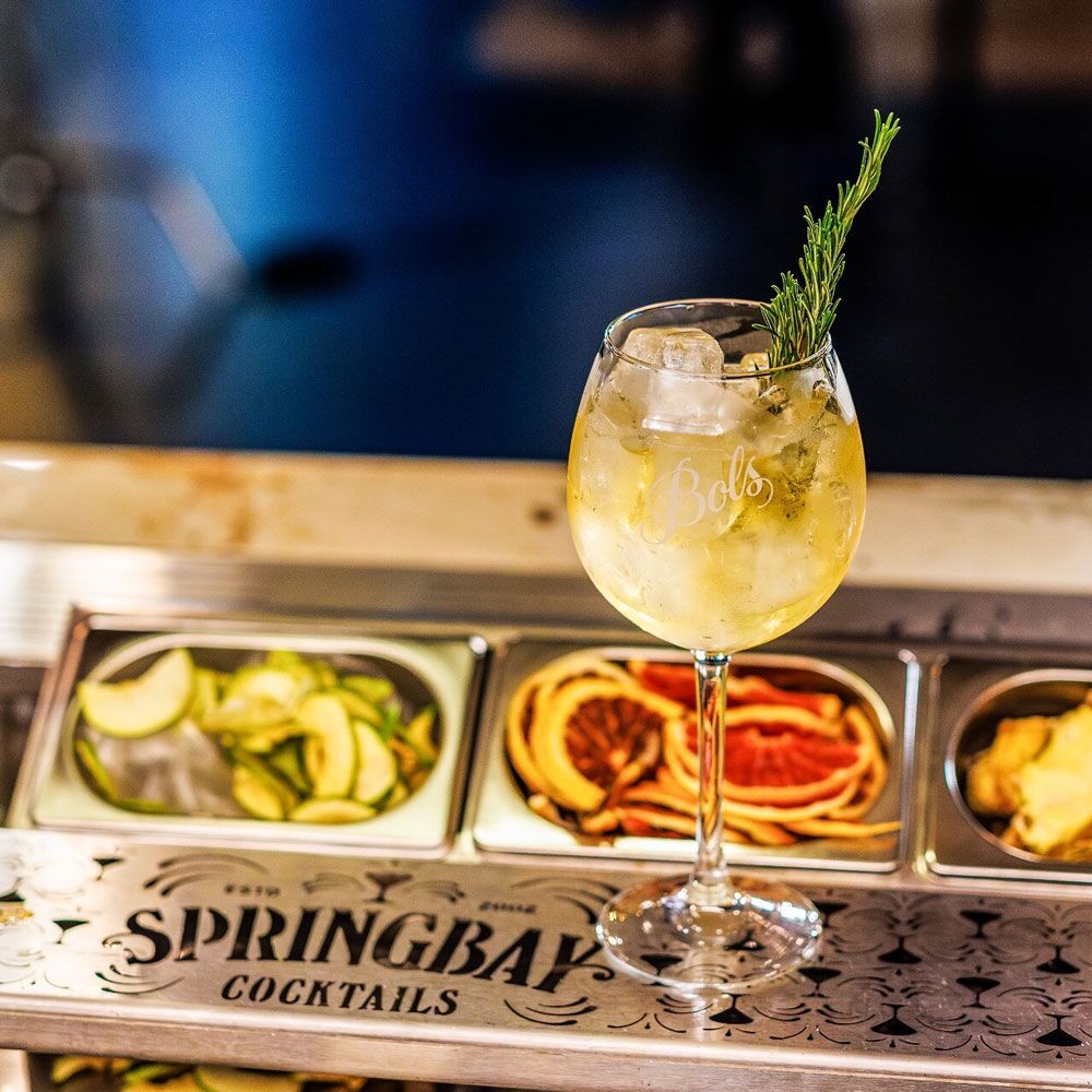 Cocktail with rosemary above the engraved garnish tray of a Springbay cocktail tap station