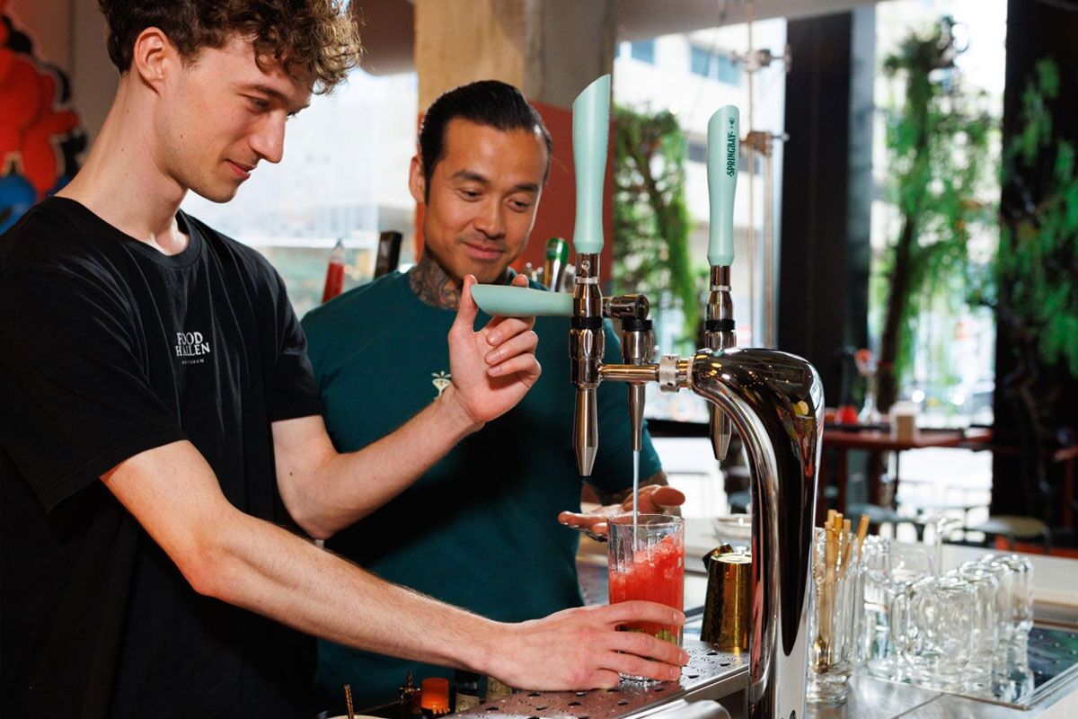 Bartender pours a cocktail from the Springbay station at Foodhallen