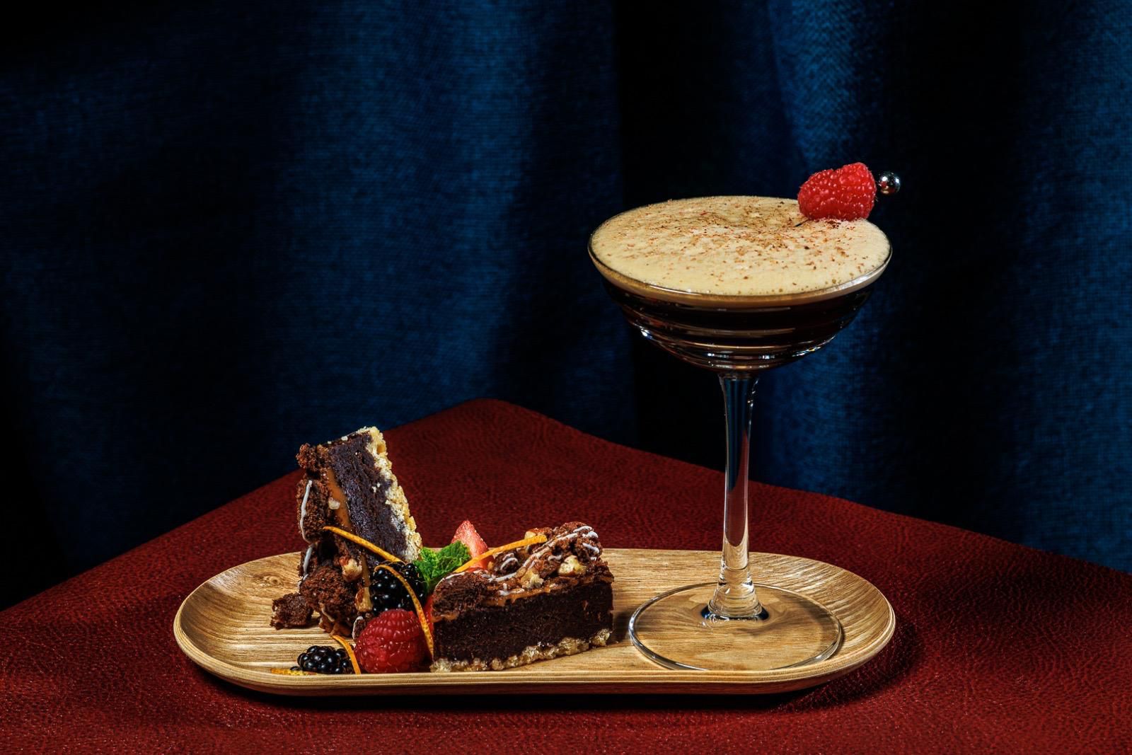 Espresso martini with a raspberry next to a dessert plate during the holidays