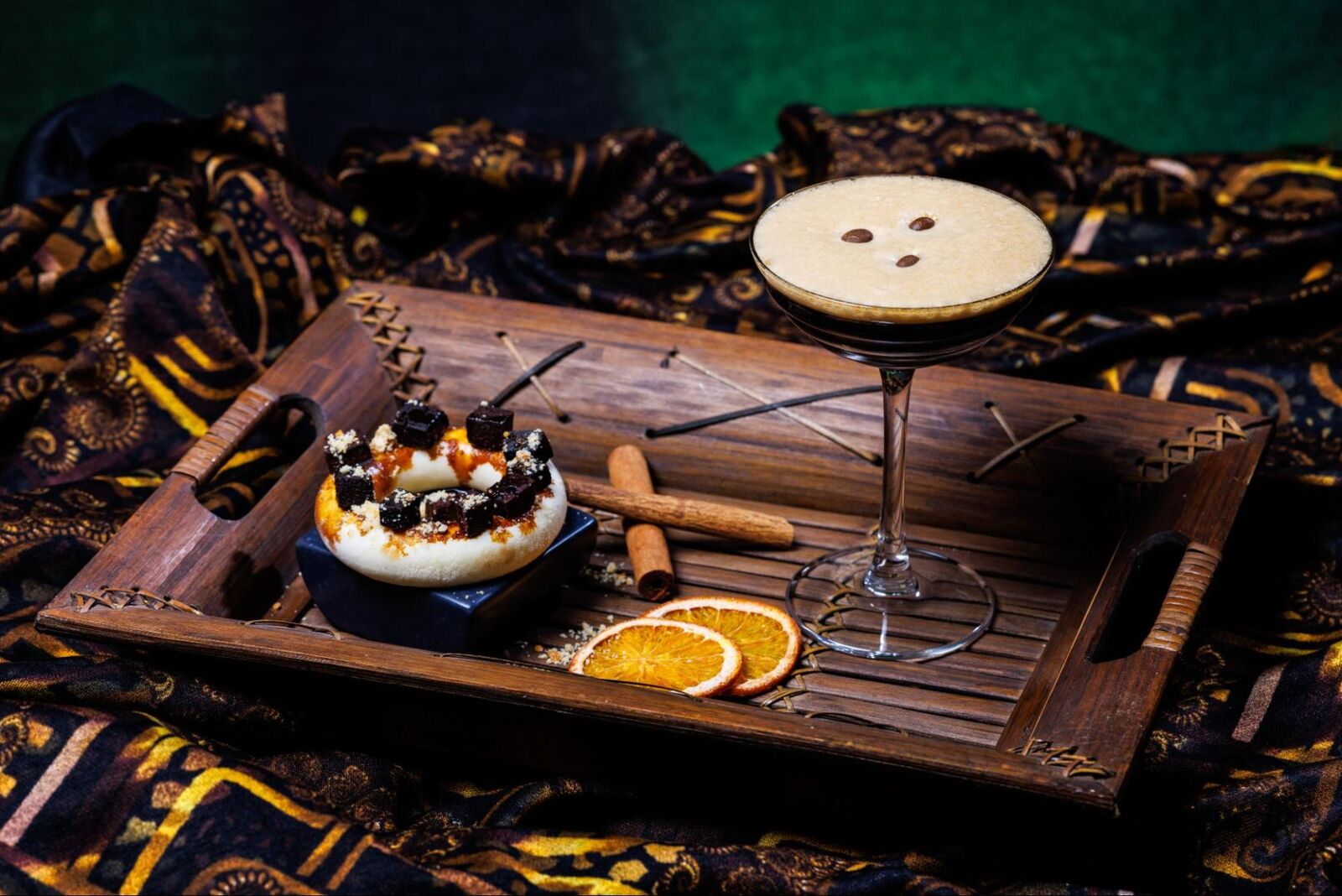 Espresso martini on a wooden board with desserts and dried orange