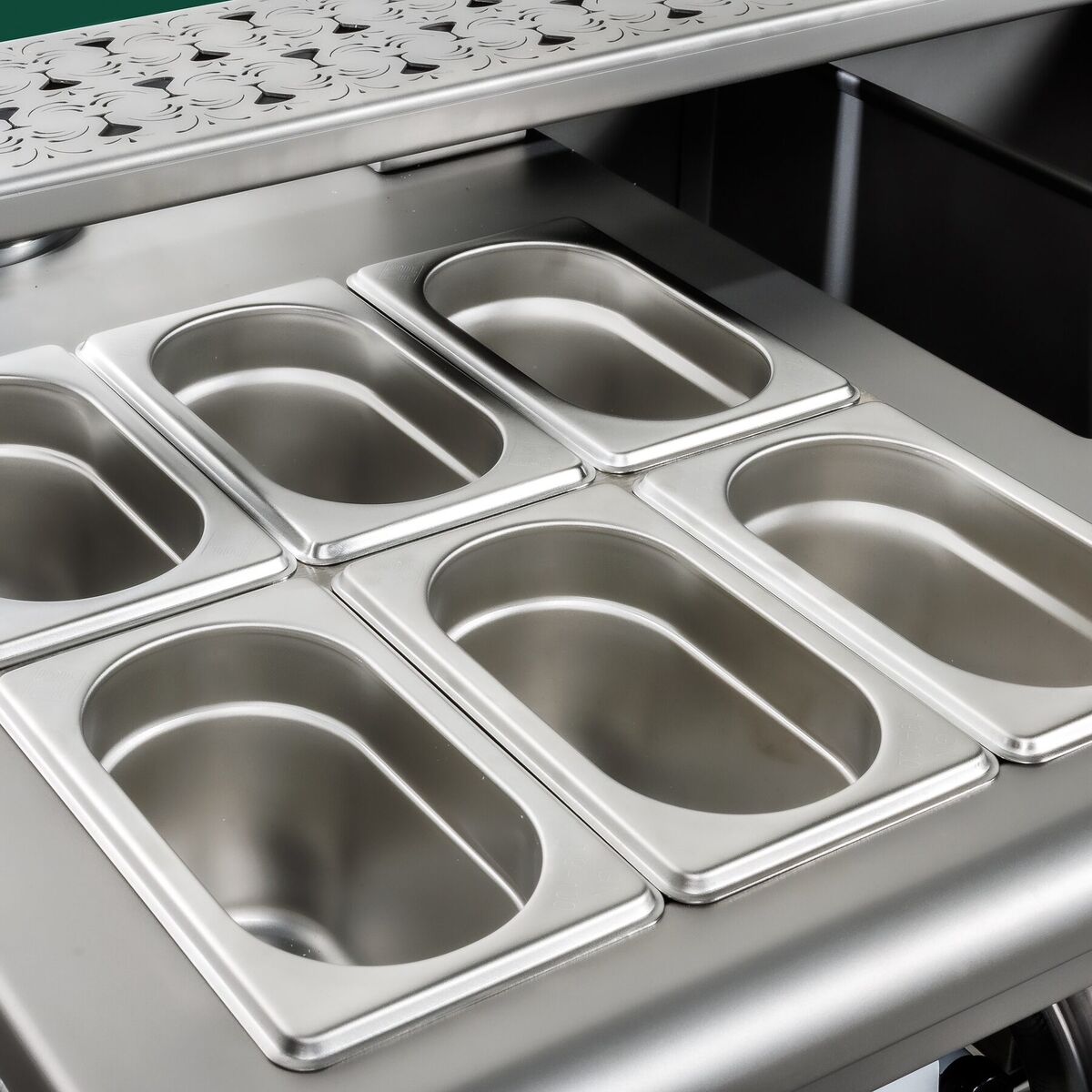 Row of stainless steel garnish trays in the station's chilled rail