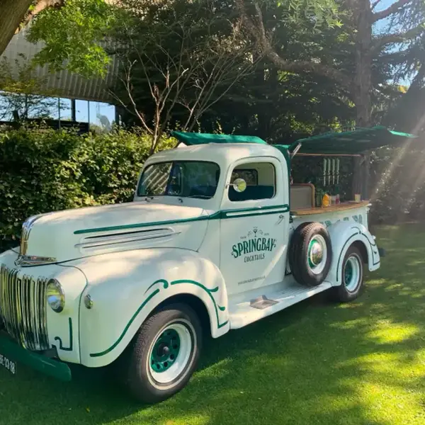 Klassischer weißer Ford-Pick-up mit Springbay-Schriftzug, als Cocktailtruck ausgestattet